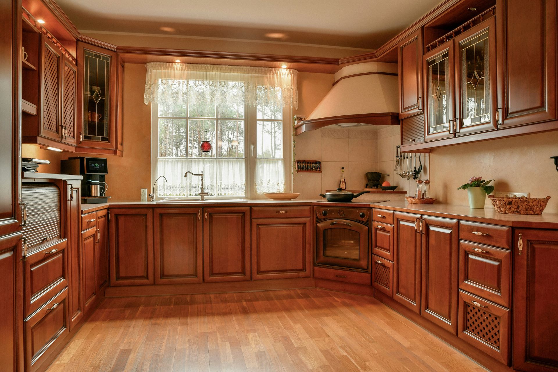 A cozy kitchen with wooden cabinets and a large window.